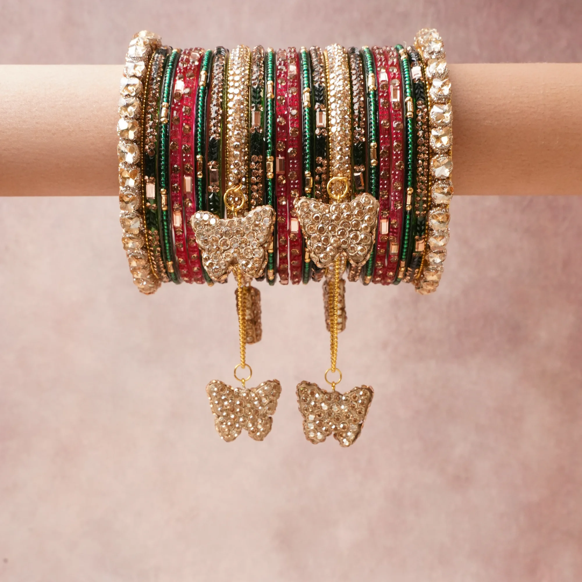 A commanding Green anchors this beautiful set, enriched with accents of Ruby Red, Gleaming Gold that add depth and dimension.

Featuring a striking composition of Glass (Bangles), Metal Alloy (Gold-toned settings, structural bangles, chains), Faceted Glass Crystals (Embellishments, charms), Seed Beads, this set carries intricate craftsmanship and strong presence. Grand in form, it is created for moments that deserve to be marked.